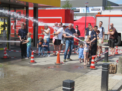 844104 Afbeelding van enkele kinderen die met de hulp van brandweerlieden van de jeugdbrandweer op een doel mogen ...